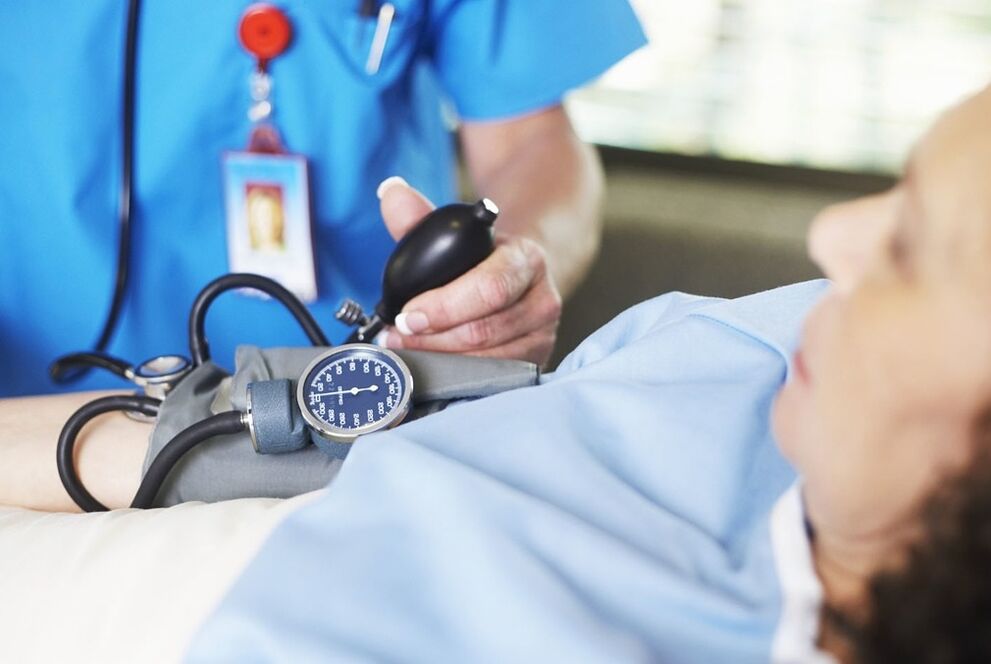 Medikuak hipertentsioarekin gaixoaren presioa neurtzen du
